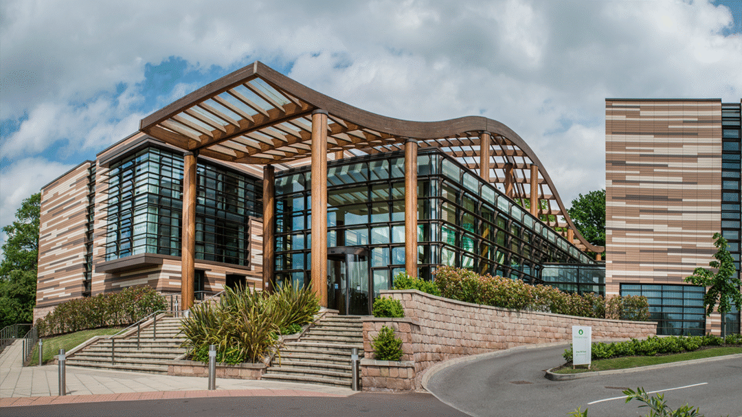 Modern glass and timber-fronted Nottingham Venues building surrounded by landscaped gardens, representing premium conference and event spaces in Nottingham
