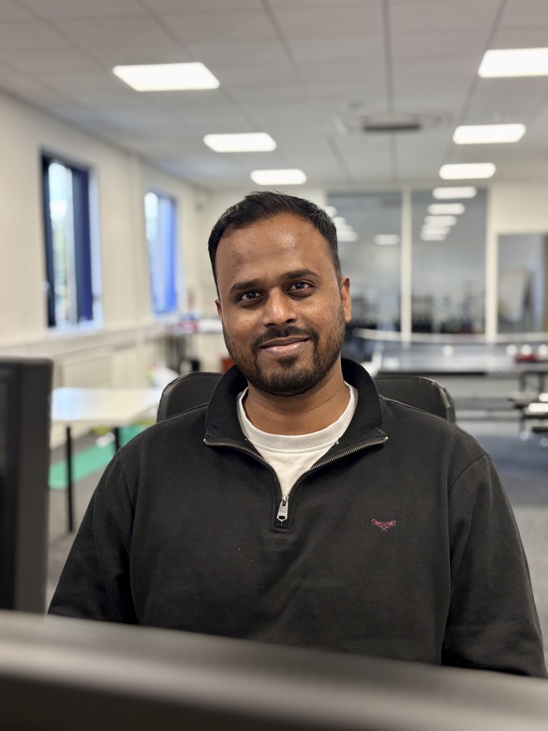 Repeat Digital team member smiling at their desk in the office