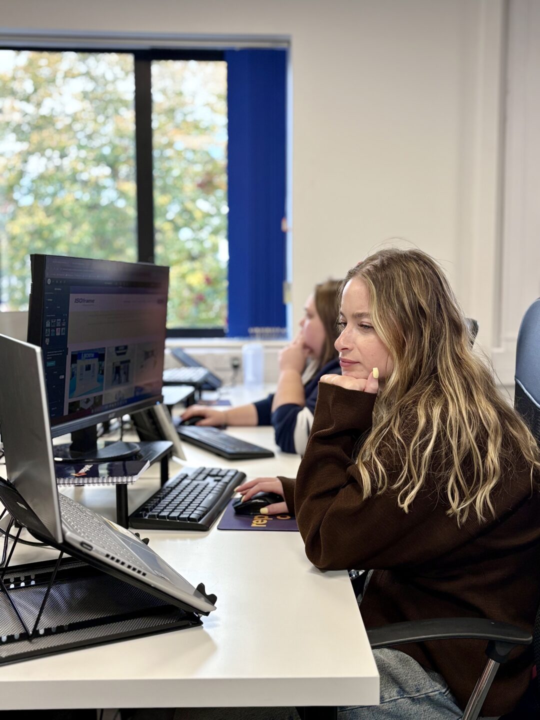 Two team members working at their desks in the Repeat Digital office
