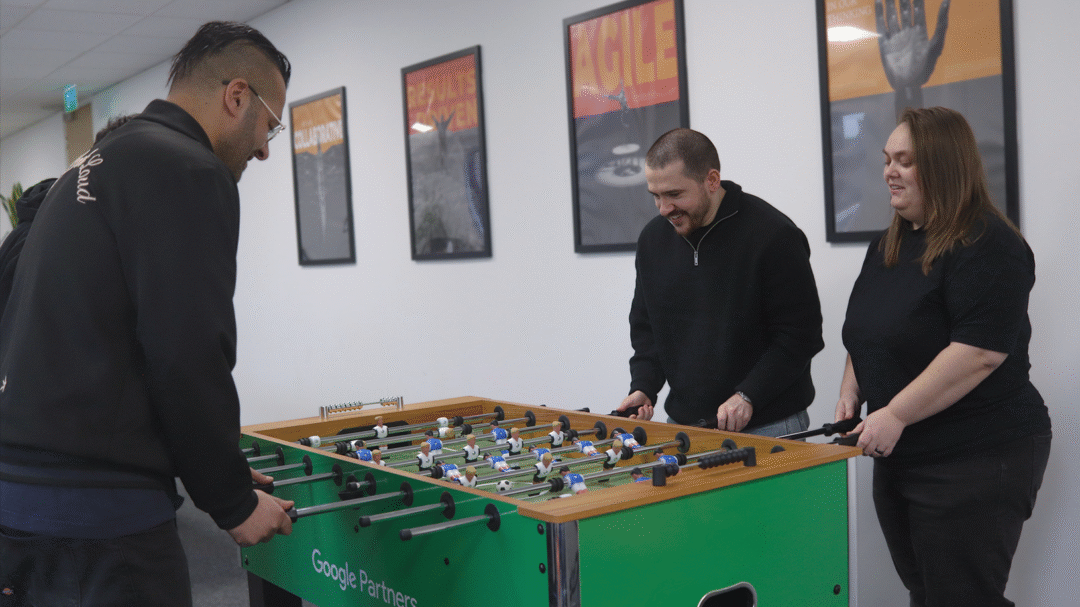 Repeat Digital team members enjoying a game of table football in the office breakout area