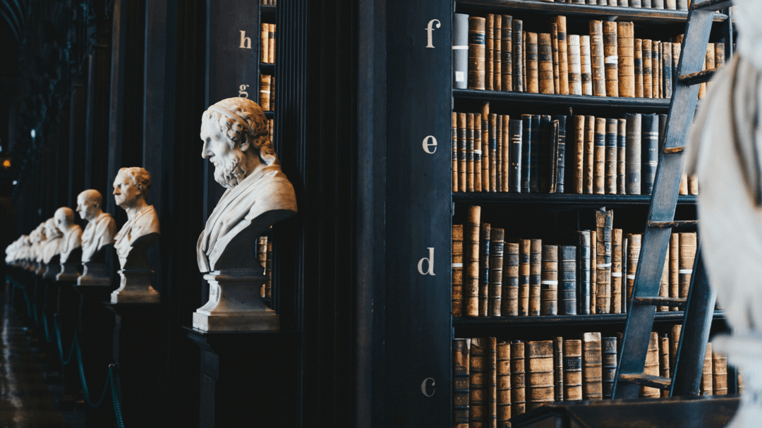 Historic library interior with marble busts and tall bookshelves