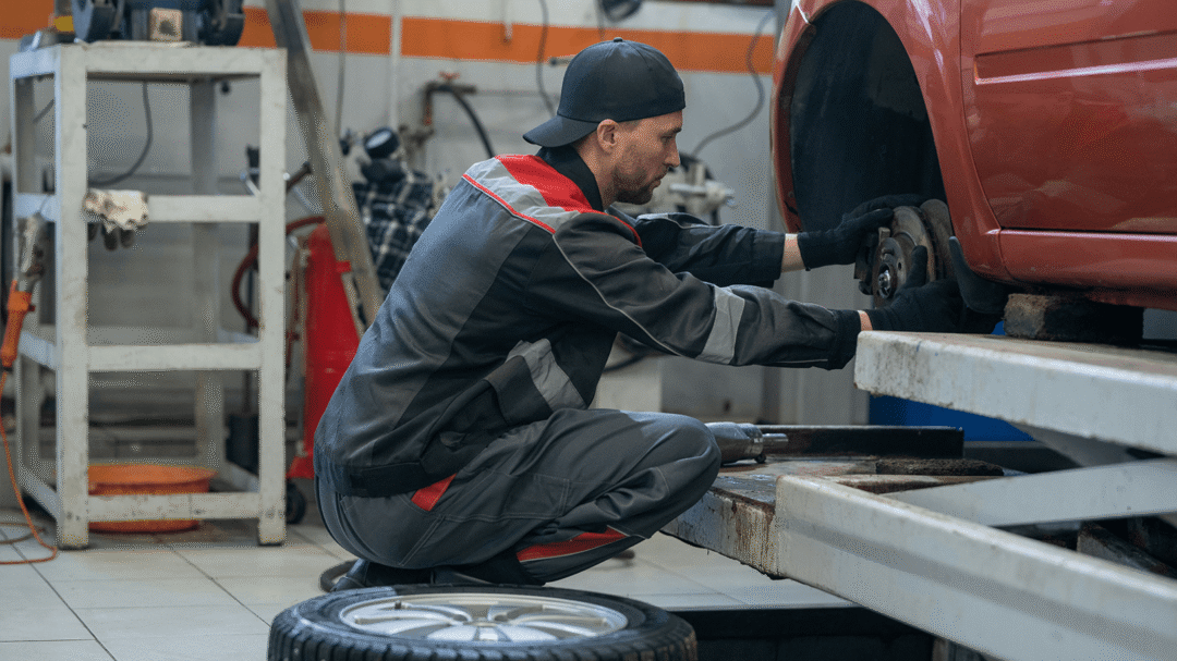 Mechanic in a workshop repairing a car wheel