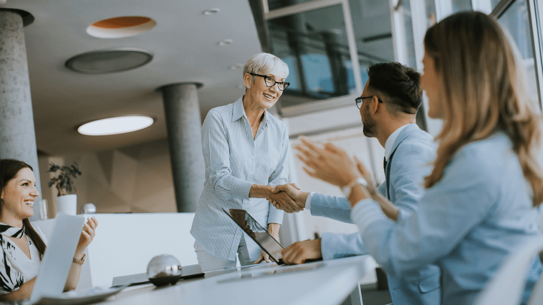 Professional business meeting with senior woman shaking hands with colleague