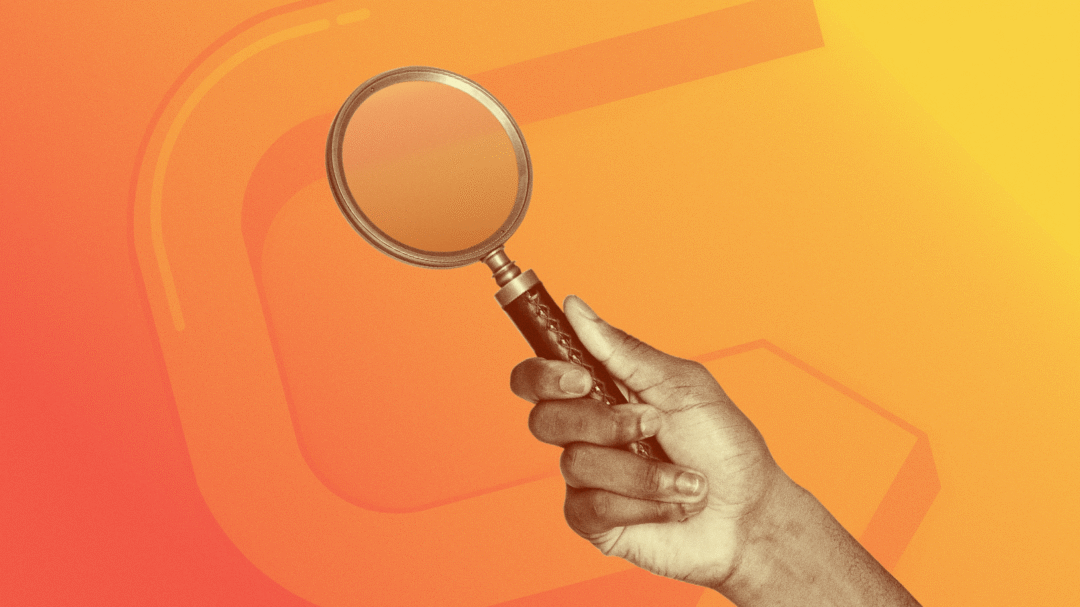 Magnifying glass held by hand on orange background symbolising research and digital marketing discovery