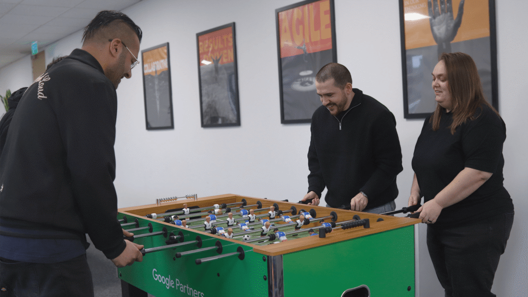 Repeat Digital team members enjoying a game of table football in the office breakout area