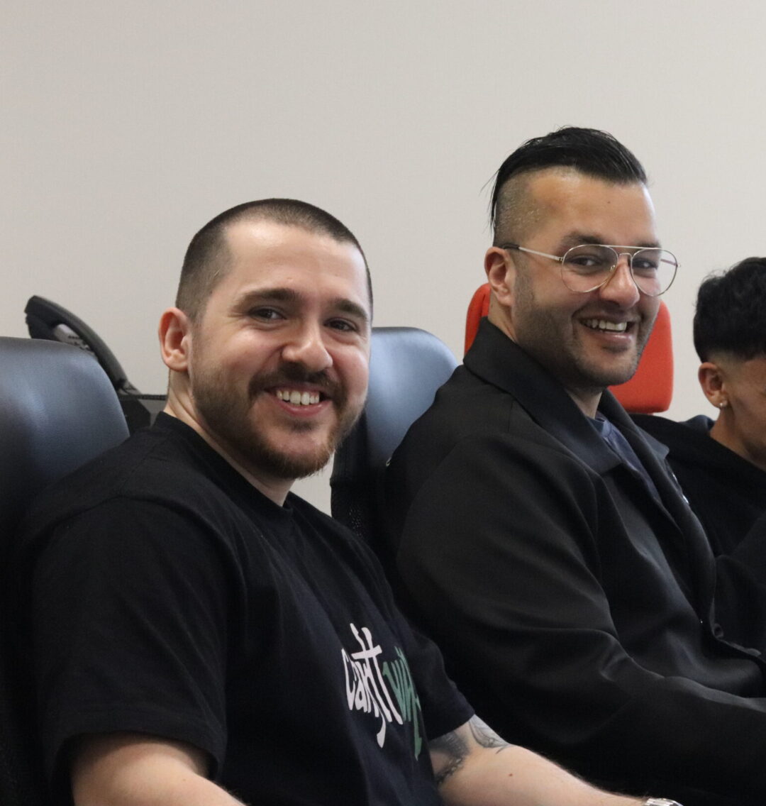 two Repeat Digital team members smiling while working at their desk