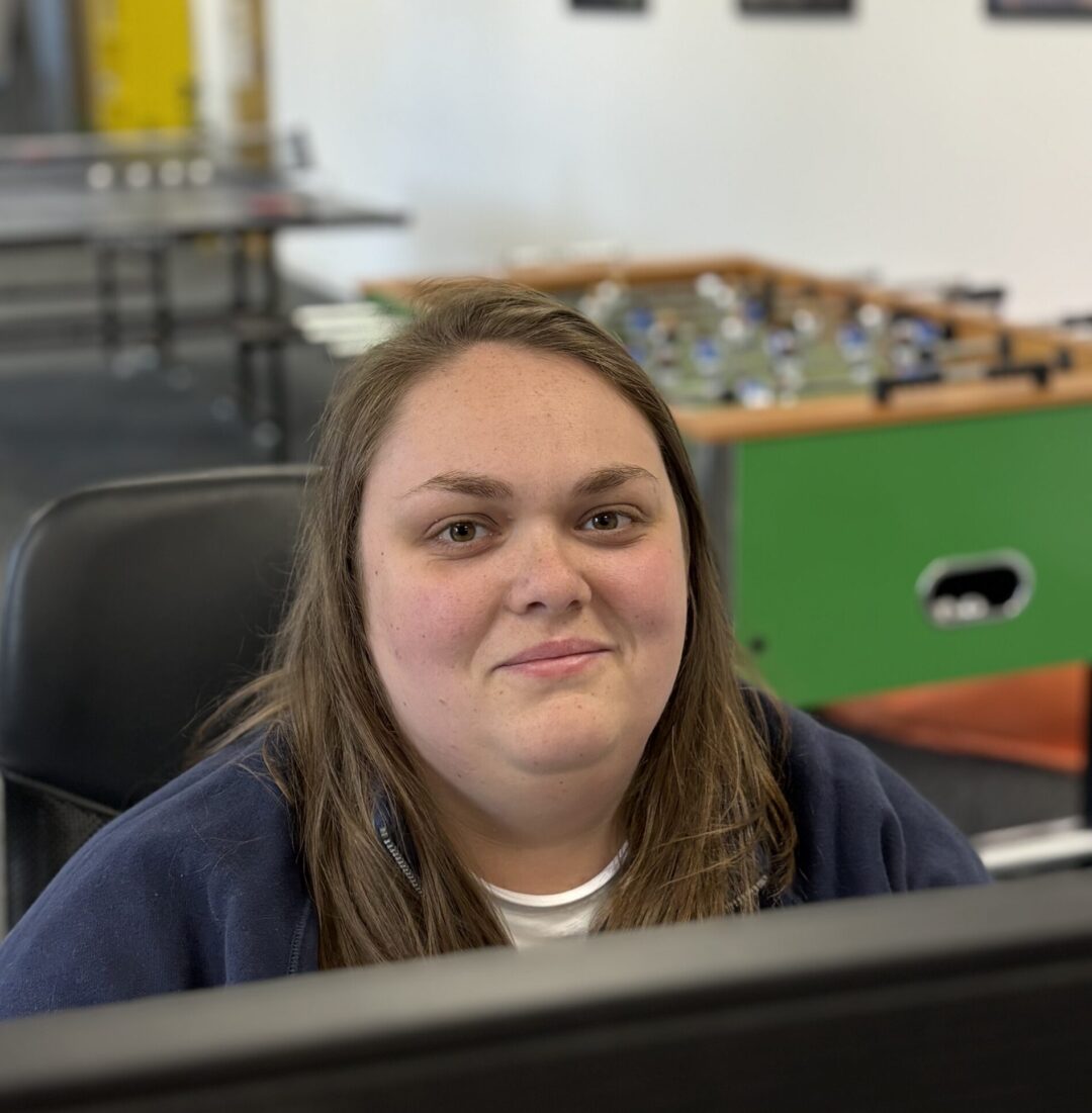 Repeat Digital team member smiling at their desk in the office